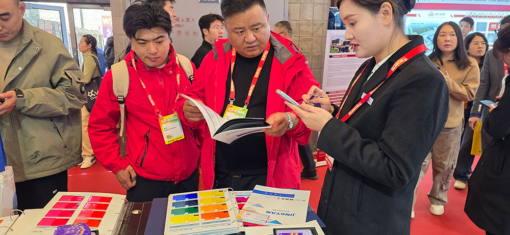 工作人员现场向客户介绍颜料色卡